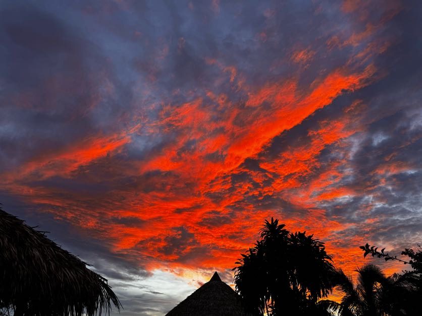 Fiery Amazon sky over the thatched roofs