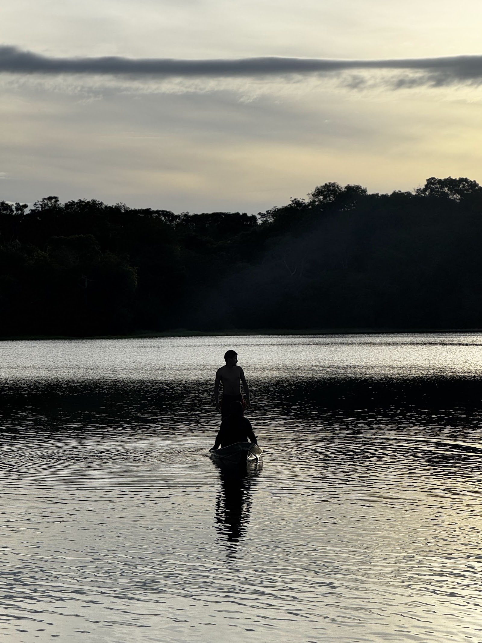 Fisherman standing on the calm lake