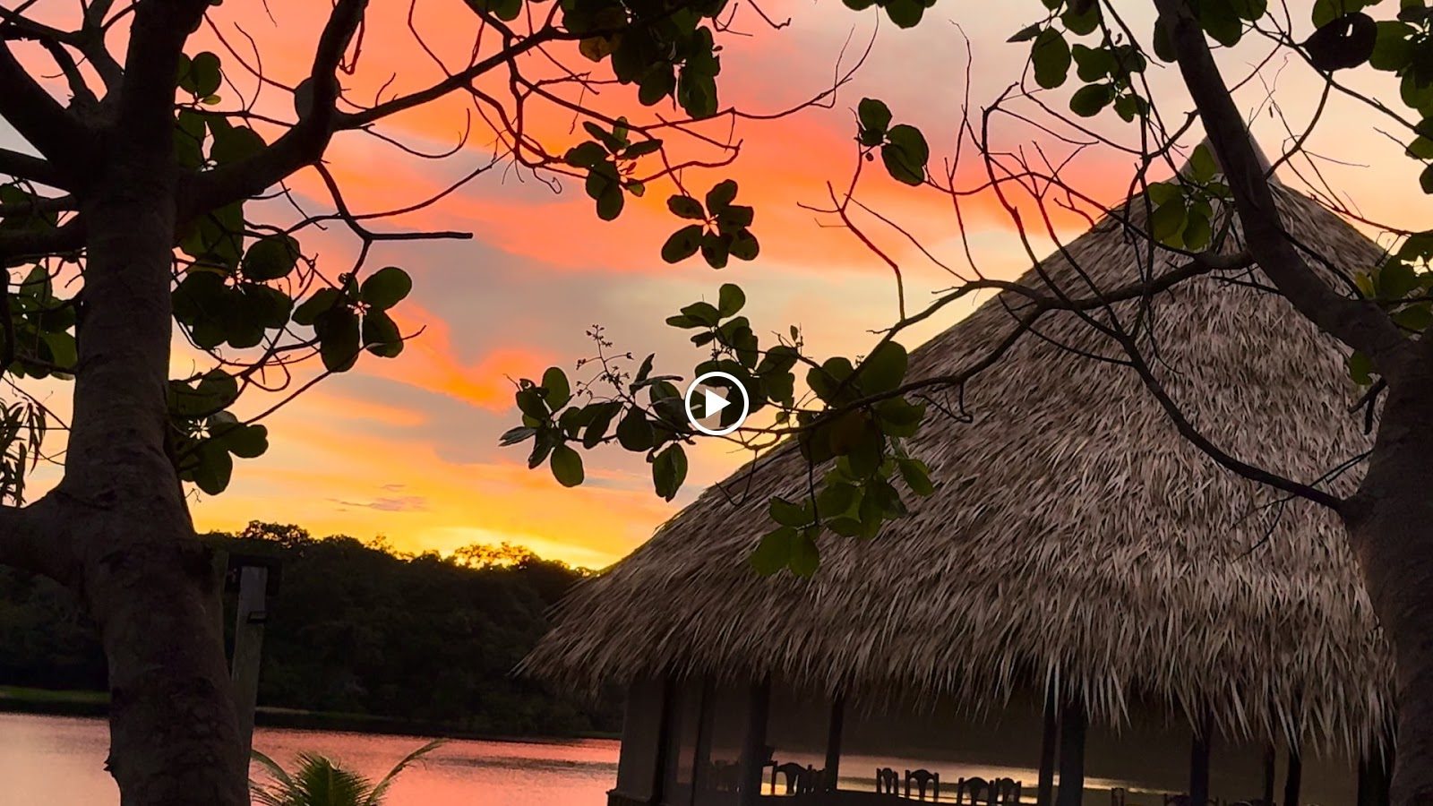 Thatched lodge at sunset by the lake