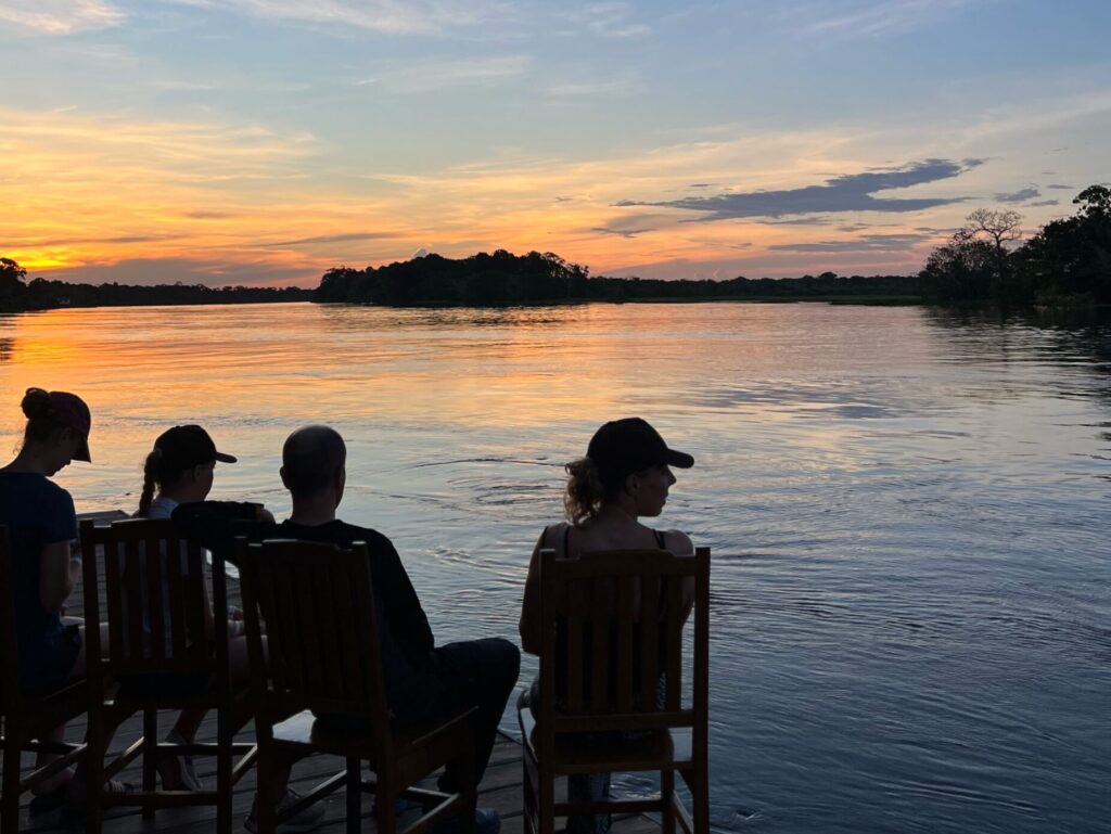 Guests watching sunset from the lodge deck on Lago Maçarico