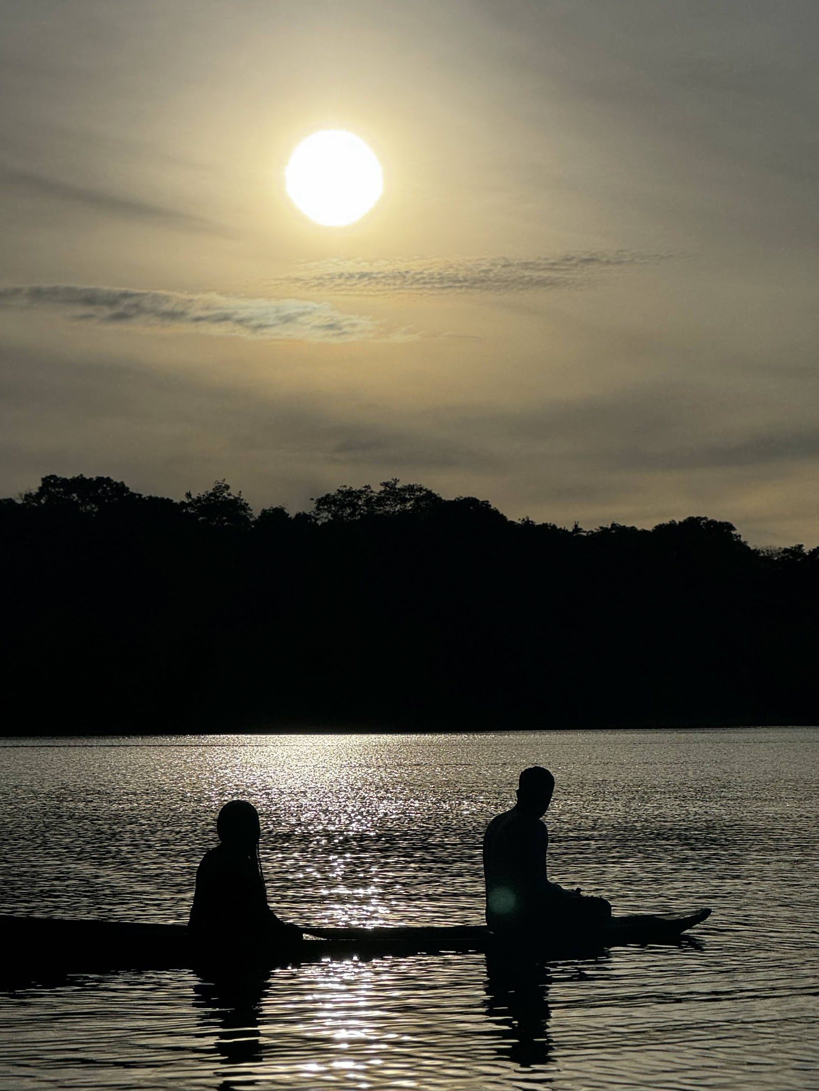 Canoe silhouettes on the lake at dusk